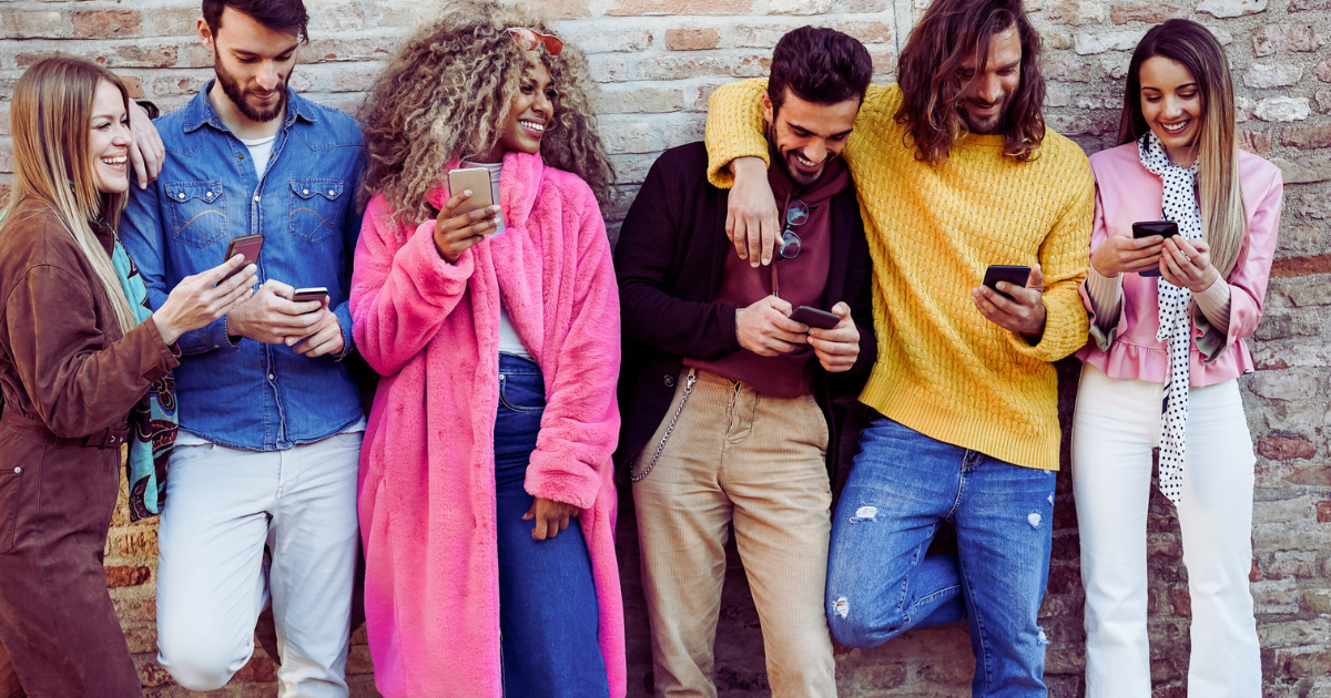 Young friends outside on smartphones