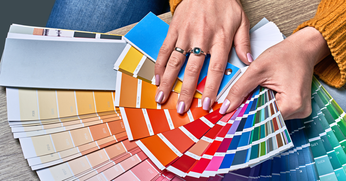 Woman's hand holding color palette swatches